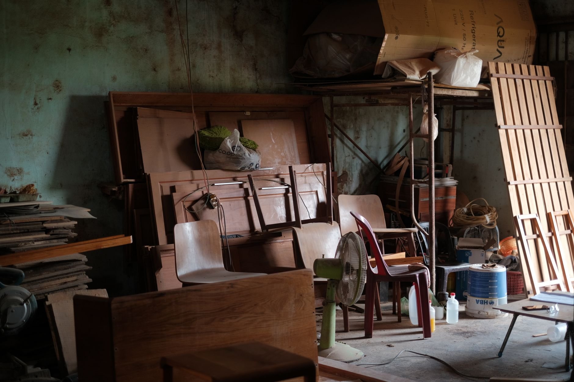 A cluttered workshop filled with wooden furniture and tools, ready for a cleanout